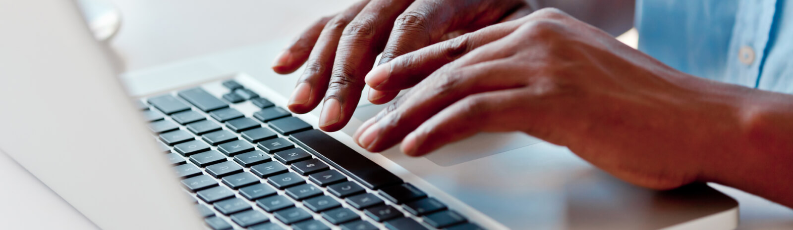 hands typing on a laptop keyboard