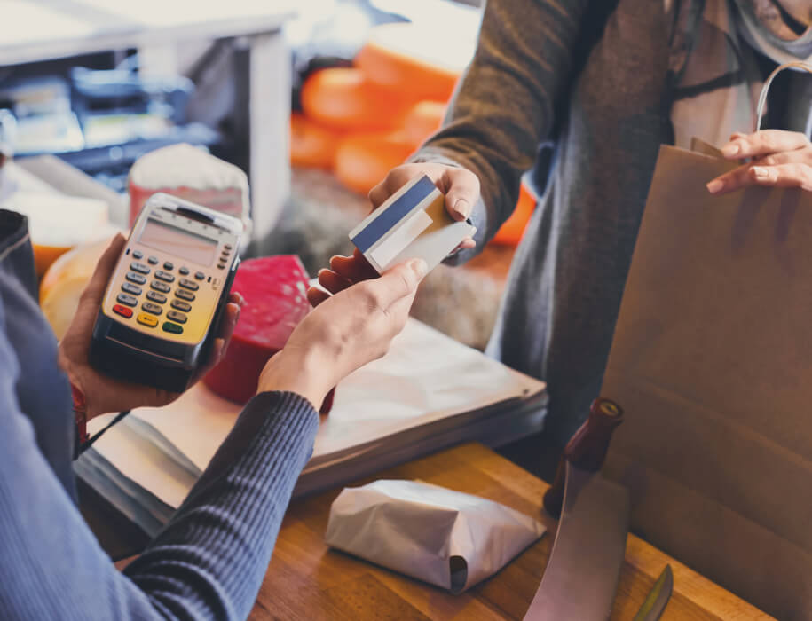 person handing a credit card to a cashier